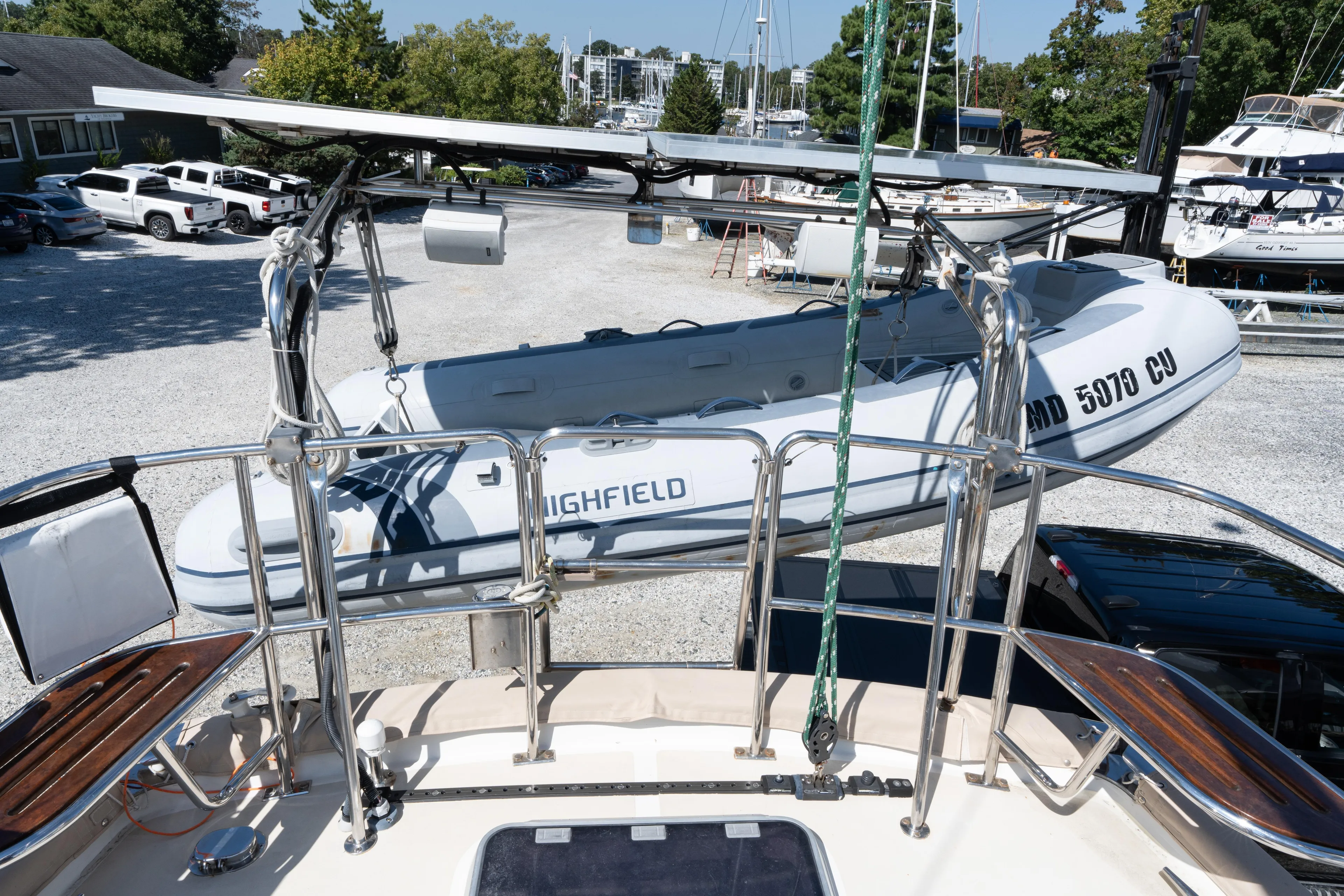 Altair Yacht Photos Pics Passport 470 Center Cockpit Ketch, 2002 model, with dinghy and solar panels in marina setting.