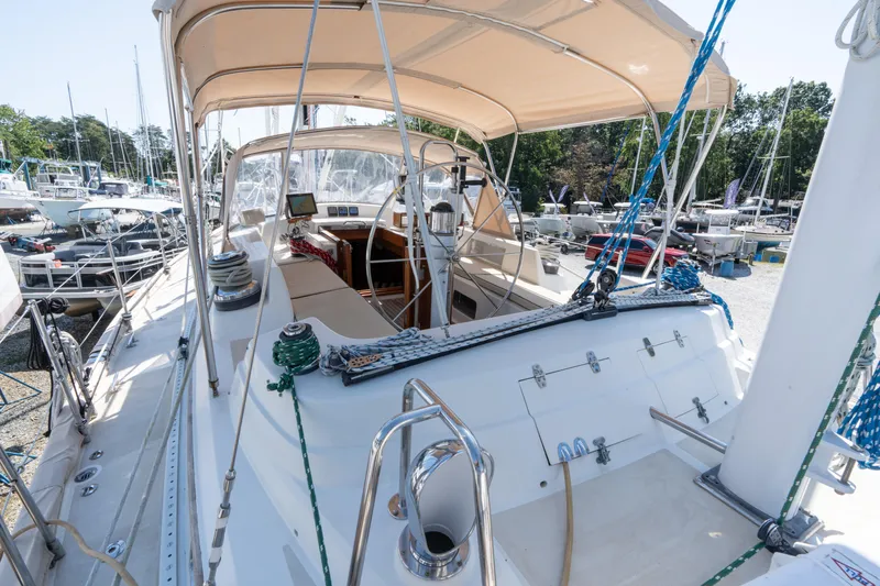 Altair Yacht Photos Pics 2002 Passport 470 Center Cockpit Ketch sailboat with covered cockpit, docked in a marina.