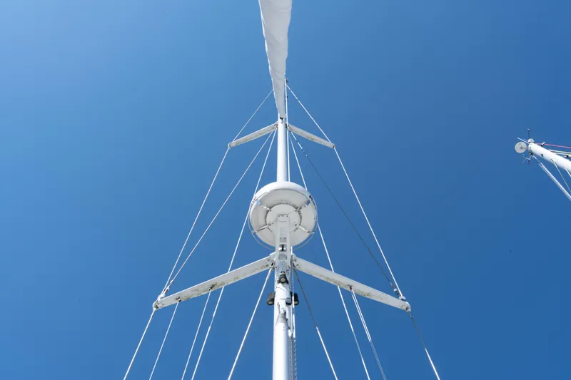 Altair Yacht Photos Pics Mast of 2002 Passport 470 Center Cockpit Ketch against clear blue sky.
