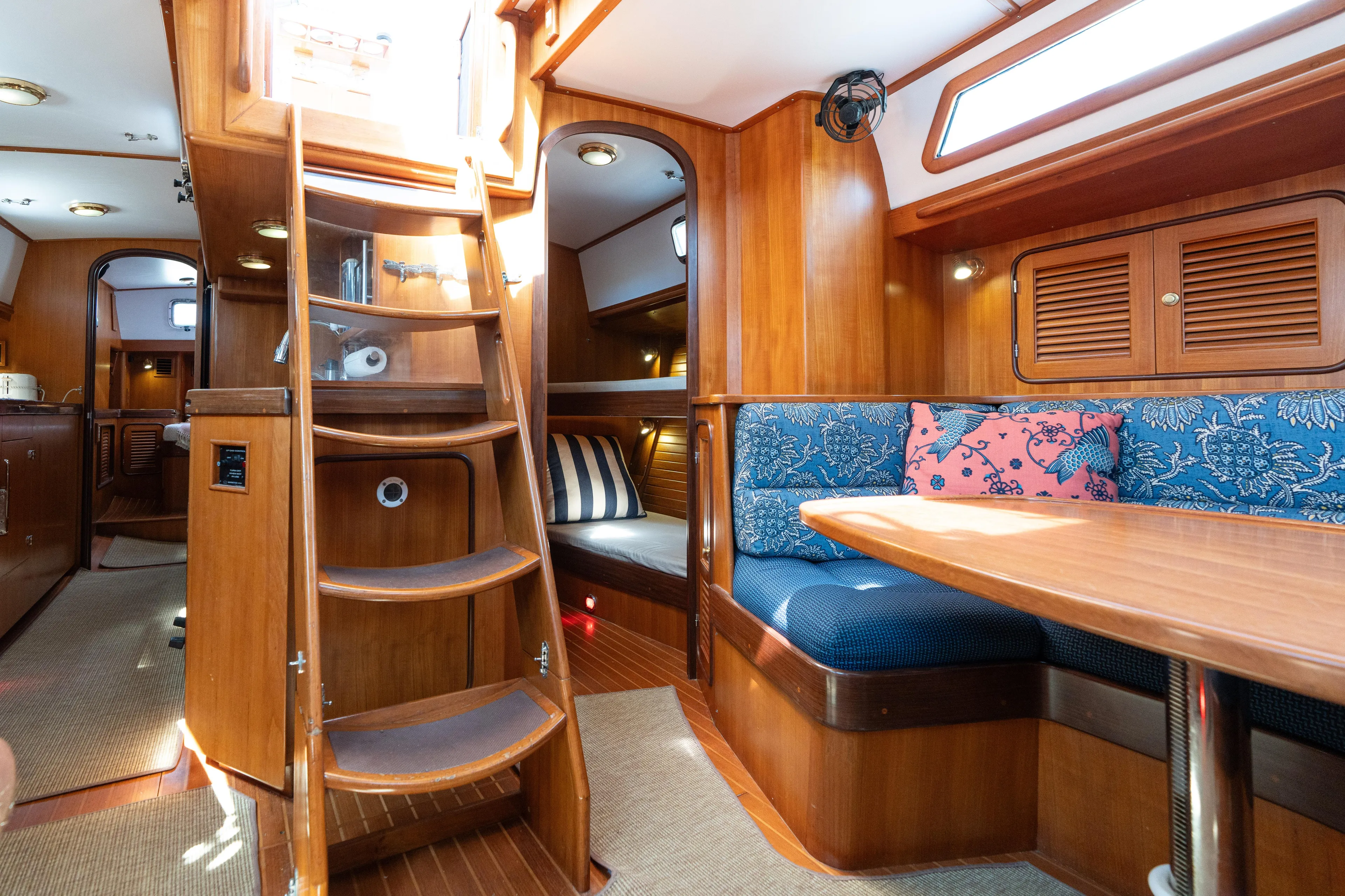 Altair Yacht Photos Pics Interior of 2002 Passport 470 Center Cockpit Ketch with wooden finish and cozy seating area.