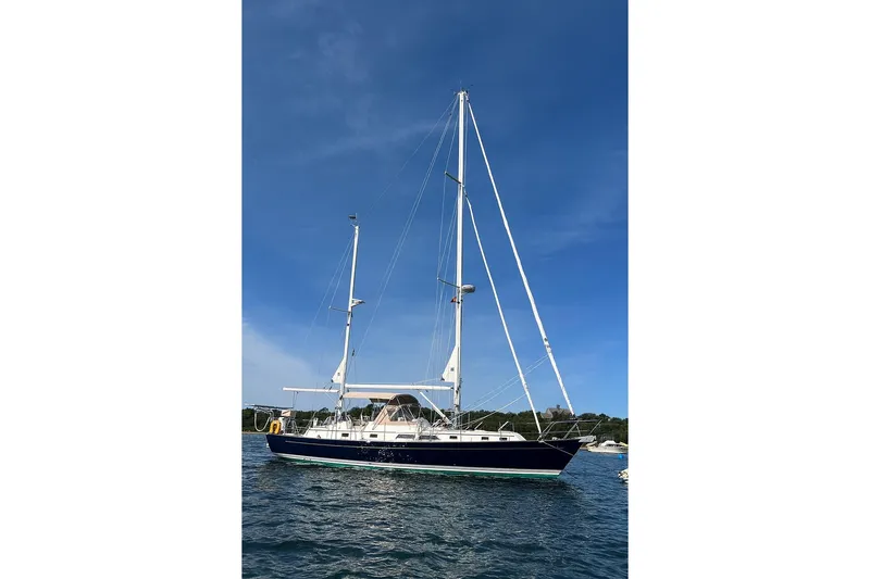 Altair Yacht Photos Pics 2002 Passport 470 Center Cockpit Ketch sailing on calm waters under clear blue sky.