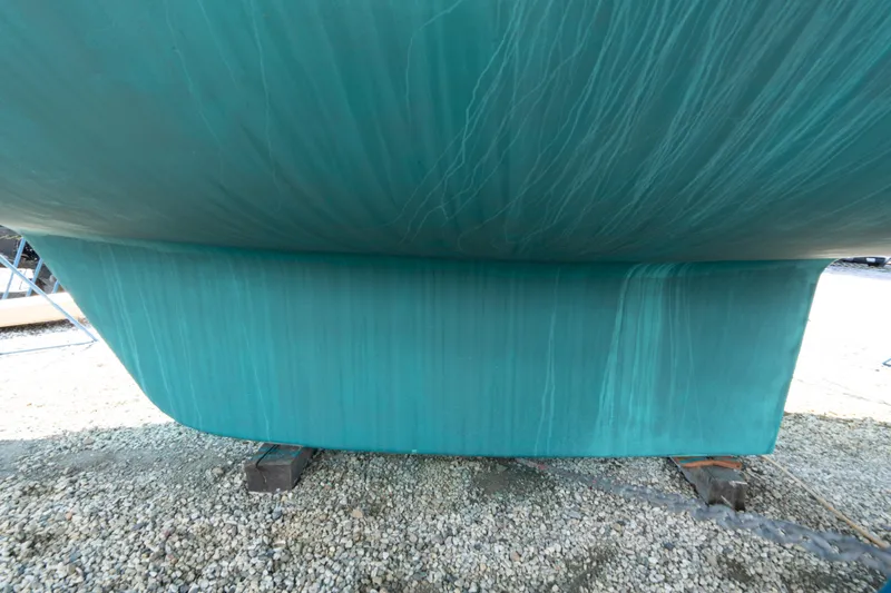 Altair Yacht Photos Pics Close-up of 2002 Passport 470 Center Cockpit Ketch hull on gravel.