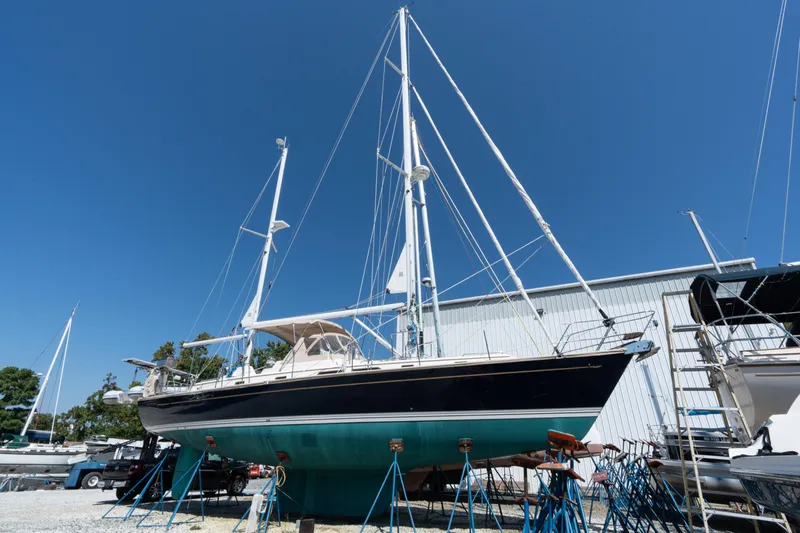 Altair Yacht Photos Pics 2002 Passport 470 Center Cockpit Ketch sailboat on stands, blue sky background.