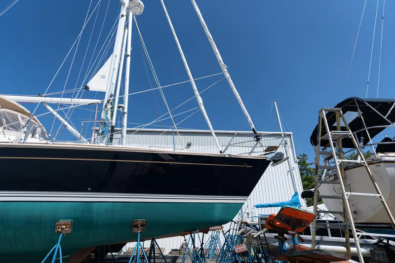 Altair Yacht Photos Pics 2002 Passport 470 Center Cockpit Ketch sailboat on stands, blue sky background.