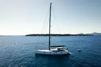 Sailing yacht CNB 66 (2021) on calm sea with island backdrop.