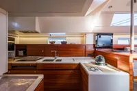 Luxurious 2021 CNB 66 yacht kitchen with modern wood cabinetry and sleek appliances.