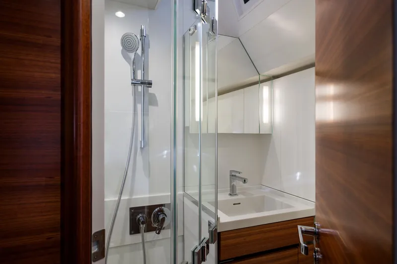 Dream On Yacht Photos Pics Modern bathroom with glass shower, sleek fixtures, and wooden accents in a 2021 CNB 66 model.