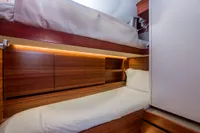Luxurious wooden bunk beds in a 2021 CNB 66 yacht cabin.