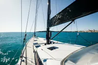Sailing yacht CNB 66, 2021 model, cruising on clear blue waters under a sunny sky.