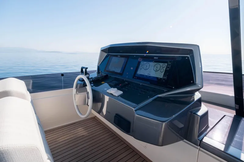 Dogu Yacht Photos Pics Helm of 2021 Ferretti Yachts 780 with modern navigation equipment, overlooking calm sea.