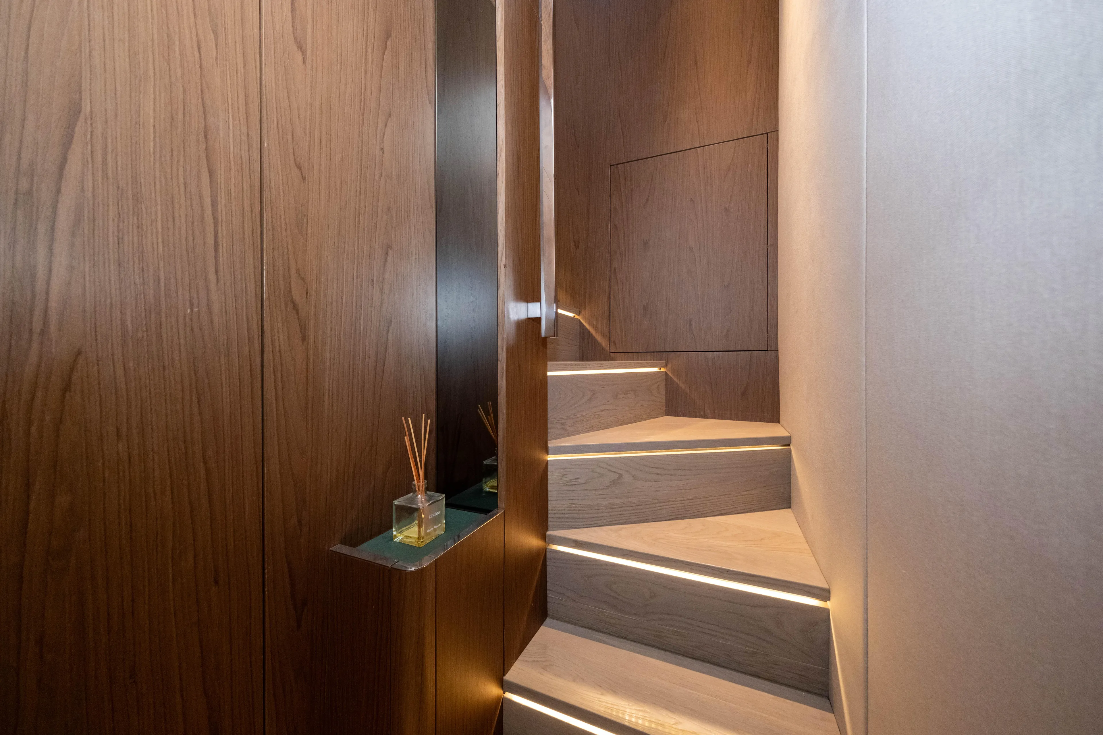 Dogu Yacht Photos Pics Interior staircase of 2021 Ferretti Yachts 780, featuring elegant wood paneling and modern lighting.