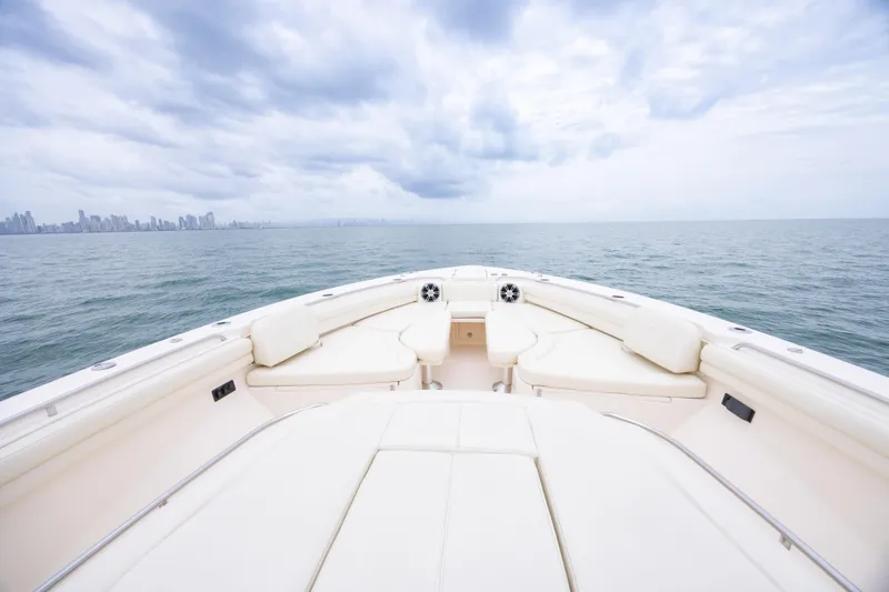  Yacht Photos Pics 2020 Grady-White Canyon 456 boat on open sea with city skyline in background.