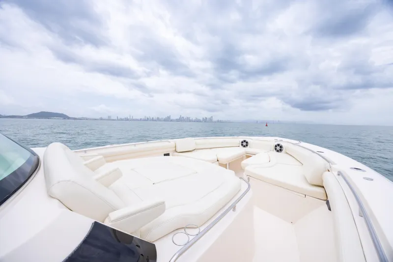  Yacht Photos Pics 2020 Grady-White Canyon 456 boat with luxurious seating, ocean view, and city skyline in background.