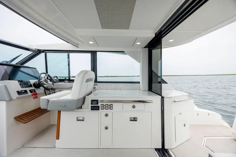  Yacht Photos Pics 2022 Regal 36 Grande Coupe interior with helm, seating, and water view.