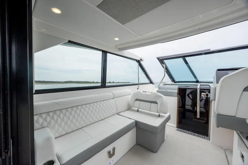  Yacht Photos Pics 2022 Regal 36 Grande Coupe interior with luxurious seating and panoramic windows.