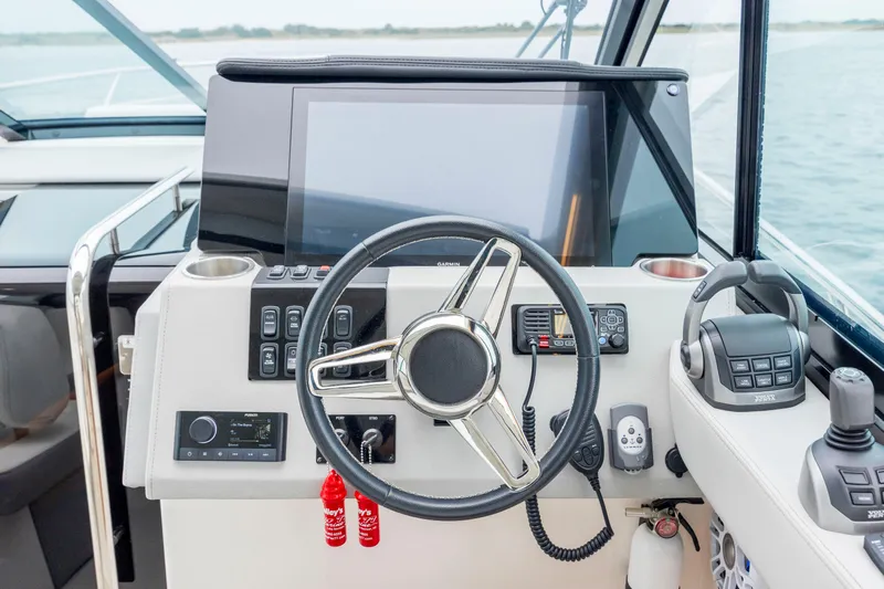  Yacht Photos Pics 2022 Regal 36 Grande Coupe helm with steering wheel, controls, and navigation display.