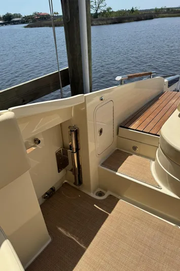 Yacht Photos Pics 2020 Chris-Craft Launch 31 GT boat interior, featuring elegant wood and beige upholstery by the water.