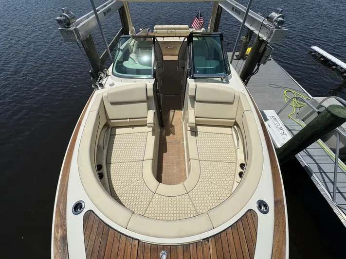  Yacht Photos Pics 2020 Chris-Craft Launch 31 GT boat with elegant seating and wooden deck, docked by the water.