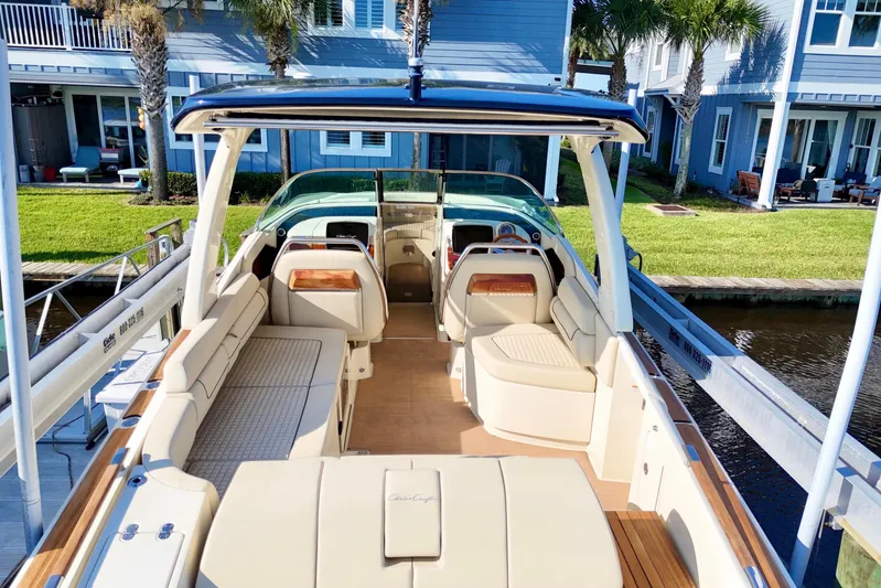  Yacht Photos Pics 2020 Chris-Craft Launch 31 GT boat with luxurious seating, docked near waterfront homes.