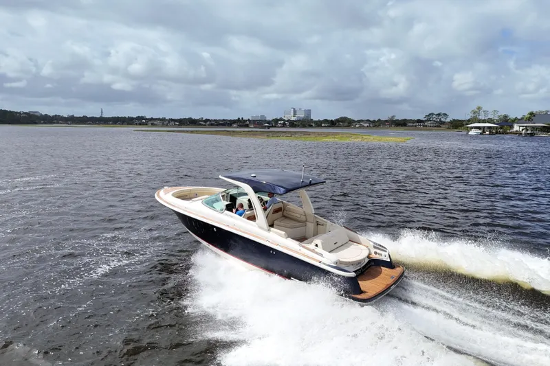  Yacht Photos Pics 2020 Chris-Craft Launch 31 GT cruising on a lake under cloudy skies.