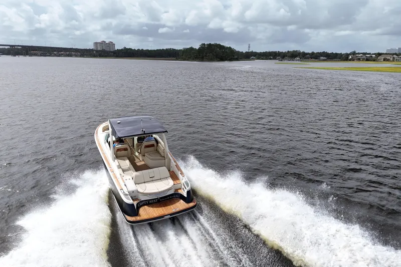  Yacht Photos Pics 2020 Chris-Craft Launch 31 GT cruising on a scenic lake under cloudy skies.