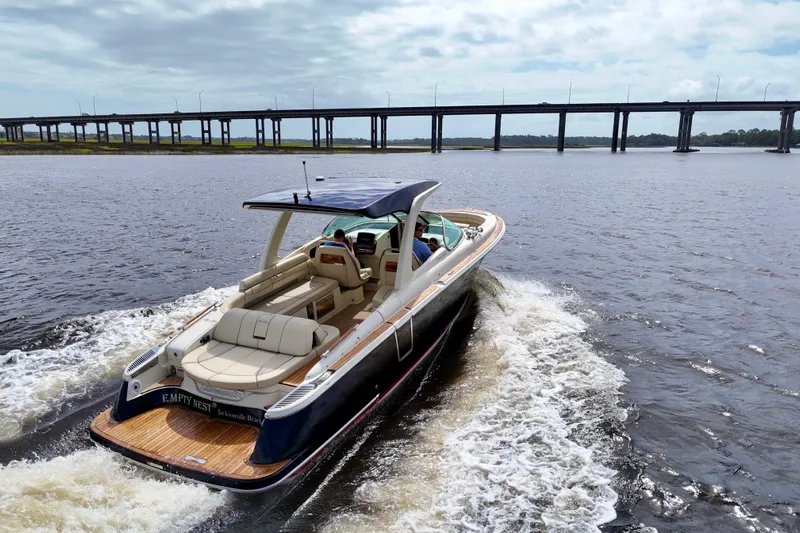  Yacht Photos Pics 2020 Chris-Craft Launch 31 GT cruising on water near a bridge, rear view.