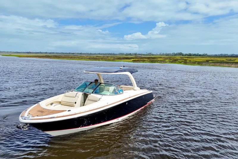  Yacht Photos Pics 2020 Chris-Craft Launch 31 GT boat on a scenic waterway under a blue sky.