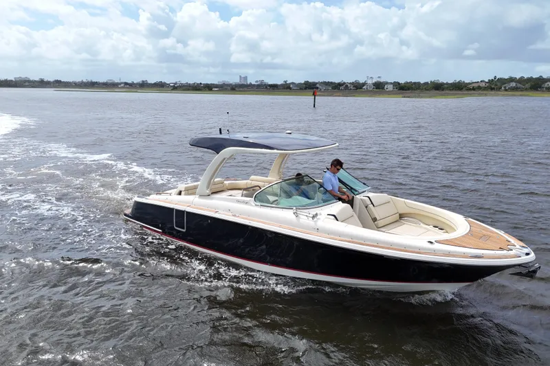  Yacht Photos Pics 2020 Chris-Craft Launch 31 GT cruising on a calm lake under a cloudy sky.