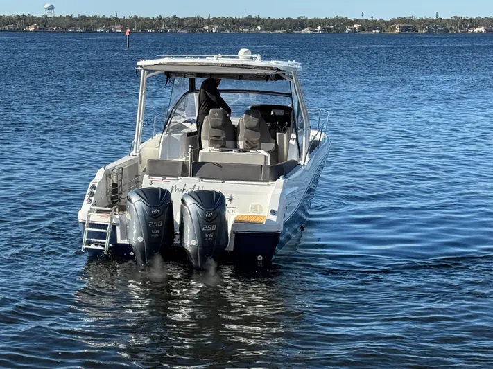 Make It Happen Yacht Photos Pics 2022 Jeanneau Leader 9.0 WA boat with twin engines on a calm lake.