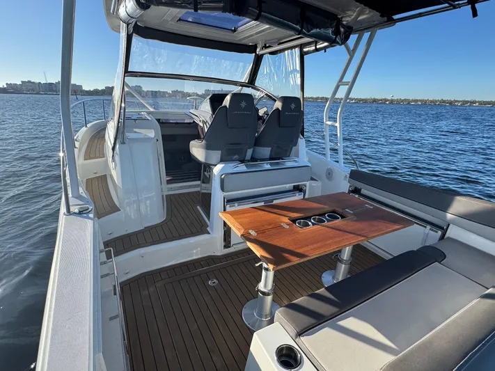 Make It Happen Yacht Photos Pics 2022 Jeanneau Leader 9.0 WA boat interior with seating and table on open water.