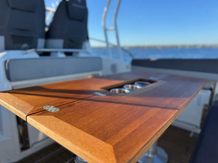 Make It Happen Yacht Photos Pics 2022 Jeanneau Leader 9.0 WA boat with wooden table and cup holders on deck.
