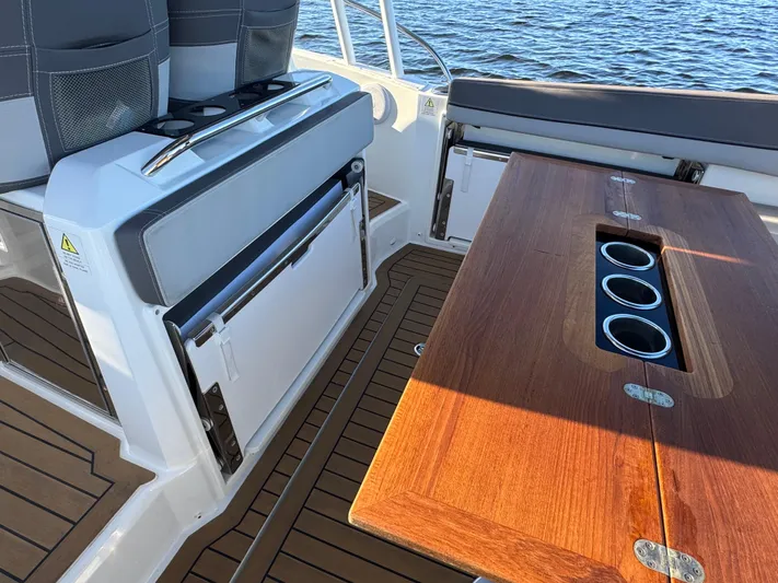 Make It Happen Yacht Photos Pics 2022 Jeanneau Leader 9.0 WA boat interior with wooden table and seating.