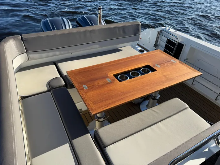 Make It Happen Yacht Photos Pics Jeanneau Leader 9.0 WA 2022 boat interior with wooden table and cushioned seating.