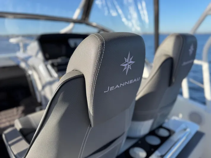 Make It Happen Yacht Photos Pics Jeanneau Leader 9.0 WA 2022 boat seats with logo, ocean view in background.