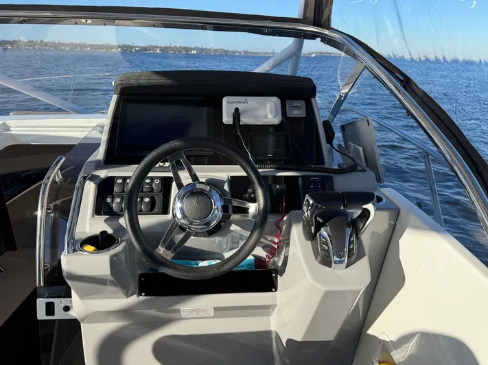 Make It Happen Yacht Photos Pics 2022 Jeanneau Leader 9.0 WA helm with steering wheel and navigation controls.