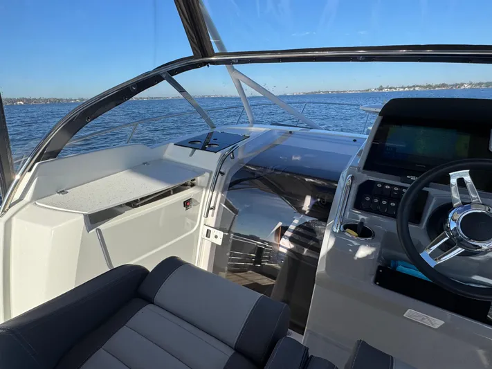 Make It Happen Yacht Photos Pics 2022 Jeanneau Leader 9.0 WA boat interior with steering wheel and dashboard on open water.