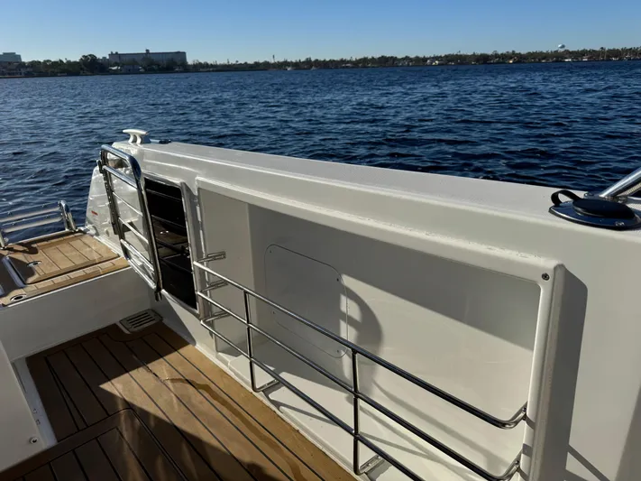 Make It Happen Yacht Photos Pics 2022 Jeanneau Leader 9.0 WA boat deck with railing, overlooking calm water.