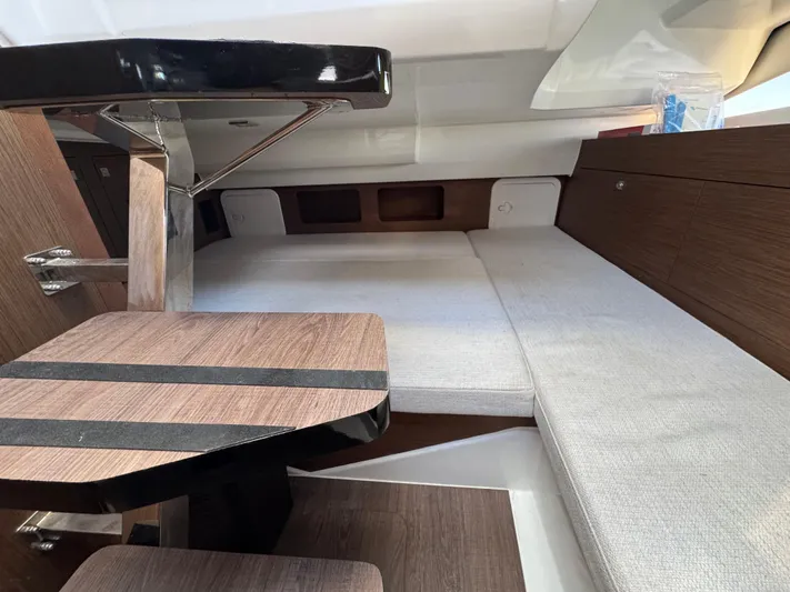 Make It Happen Yacht Photos Pics Interior cabin of 2022 Jeanneau Leader 9.0 WA with wood accents and seating.