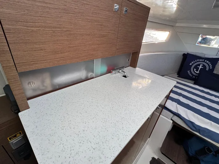 Make It Happen Yacht Photos Pics Jeanneau Leader 9.0 WA 2022 interior with sleek countertop and cozy cabin bed.