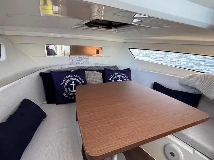 Make It Happen Yacht Photos Pics Interior of 2022 Jeanneau Leader 9.0 WA boat with cozy seating and nautical decor.