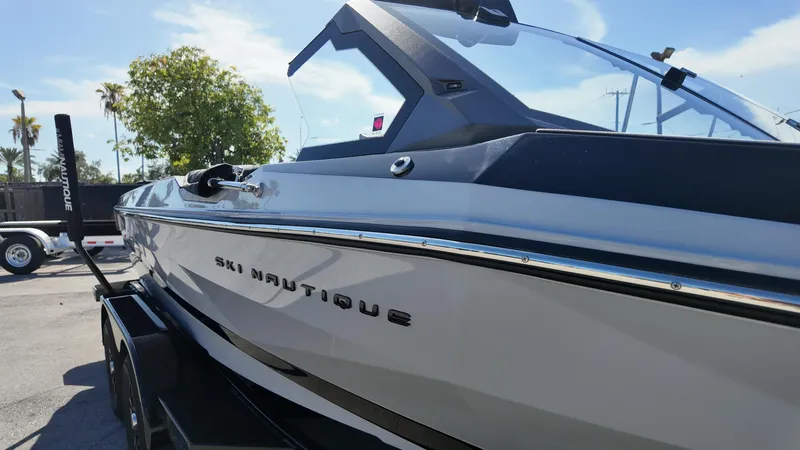  Yacht Photos Pics 2026 Nautique Ski boat in a sunny outdoor setting, showcasing sleek design and branding.