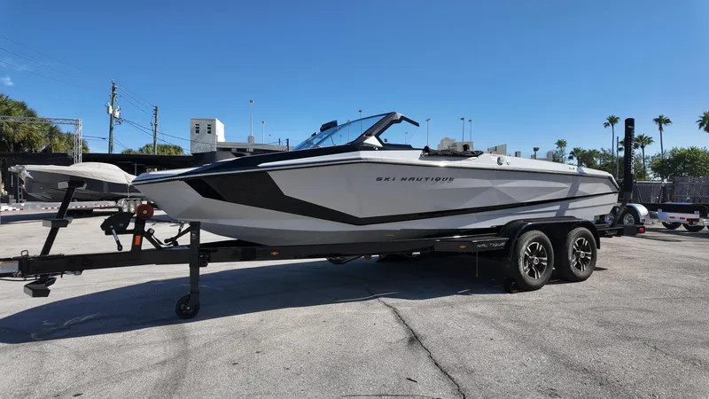  Yacht Photos Pics 2026 Nautique Ski boat on trailer under clear blue sky.