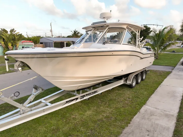 Sweet Life Yacht Photos Pics 2019 Grady-White Freedom 325 boat on trailer, parked on grass near a road.