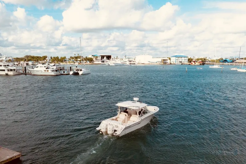 Sweet Life Yacht Photos Pics 2019 Grady-White Freedom 325 boat cruising in a marina under a partly cloudy sky.