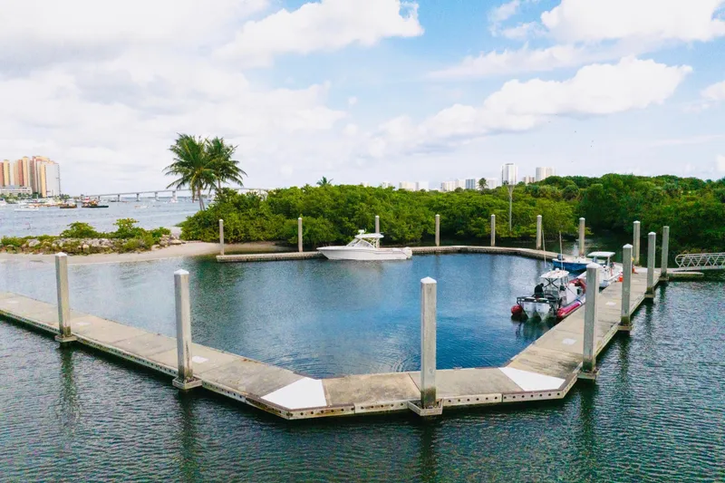 Sweet Life Yacht Photos Pics 2019 Grady-White Freedom 325 docked in a scenic marina with lush greenery and city skyline.