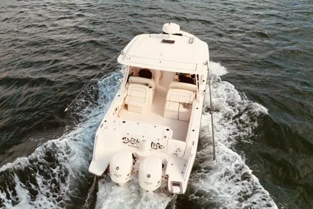 Sweet Life Yacht Photos Pics 2019 Grady-White Freedom 325 boat cruising on open water, rear view.