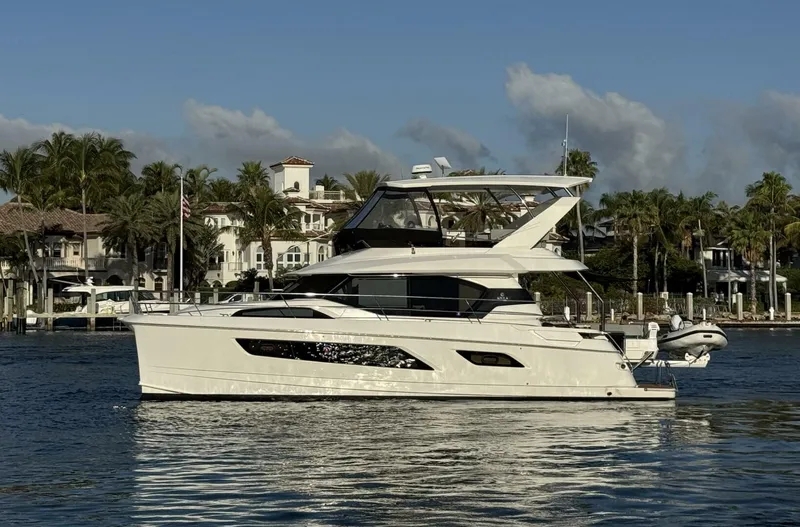 Roosterfish Yacht Photos Pics Aquila 44 yacht, 2022 model, cruising on a sunny day near waterfront homes.