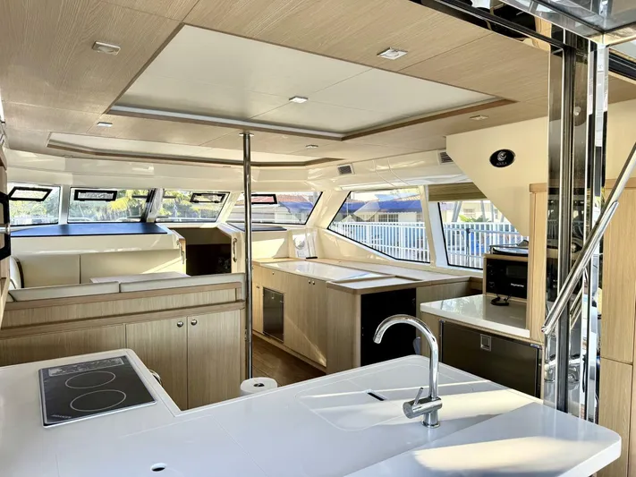 Roosterfish Yacht Photos Pics Luxurious interior of 2022 Aquila 44 yacht with modern kitchen and seating area.