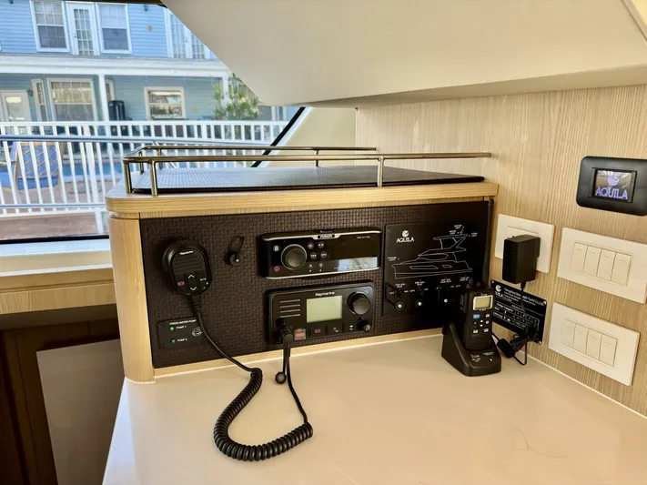 Roosterfish Yacht Photos Pics Control panel in a 2022 Aquila 44 yacht with communication equipment and switches.