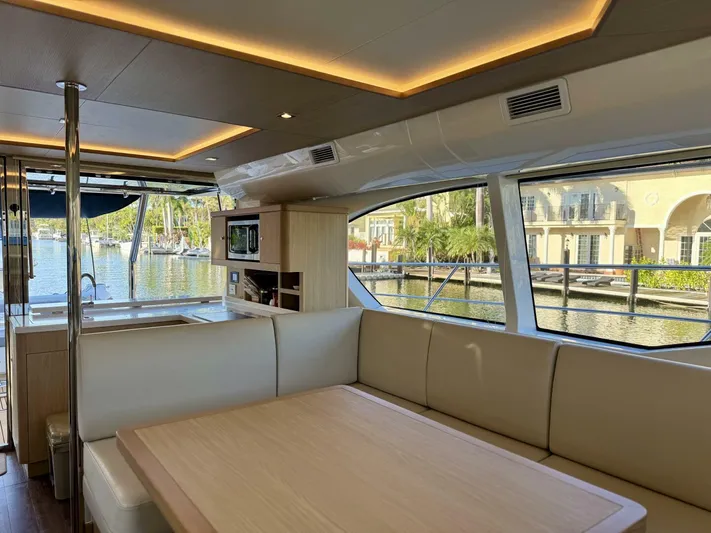 Roosterfish Yacht Photos Pics Luxurious interior of 2022 Aquila 44 yacht with spacious seating and scenic marina view.